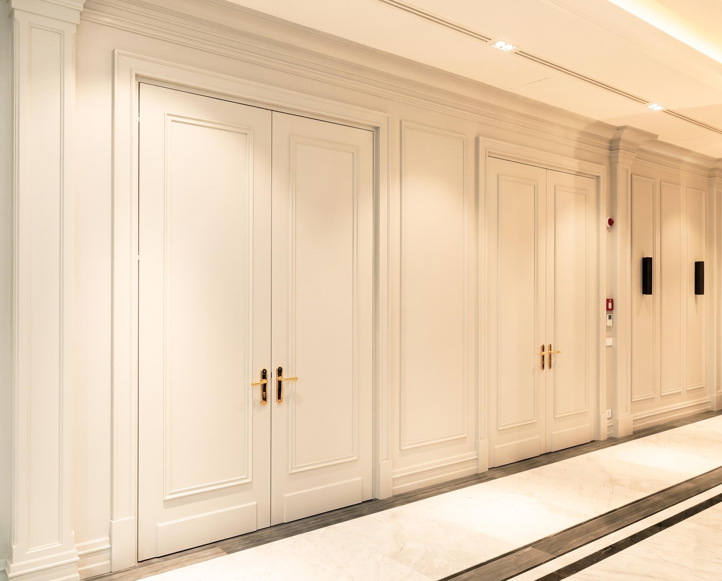 Private Bank — panelled wall — white, paired doors